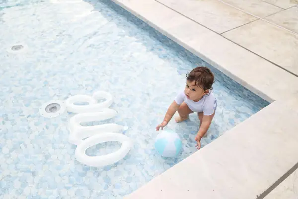 Toddler playing with a ball at the edge of a pool, outdoor family photography by Photoholic, Rockland County NY