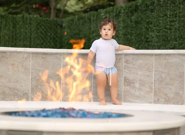 Toddler standing by an outdoor fire pit, outdoor family photography by Photoholic, Rockland County NY